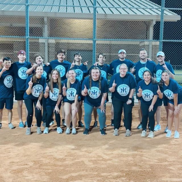 Group of young adults getting 1st place in a softball league